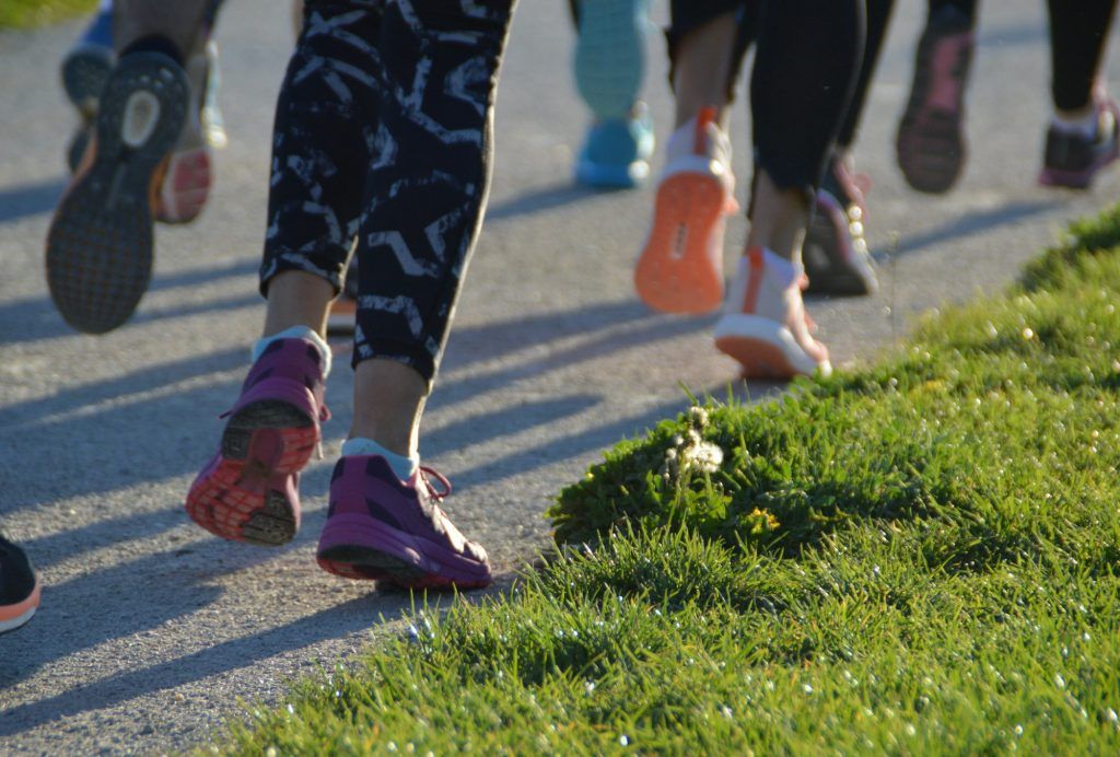 Group of people running - feet on the road