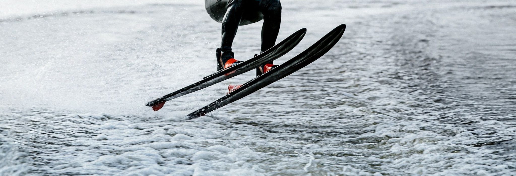 man waterskiing on lake behind boat