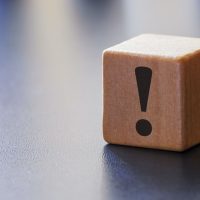 Warning exclamation mark on a wooden block Warning exclamation mark on a wooden block